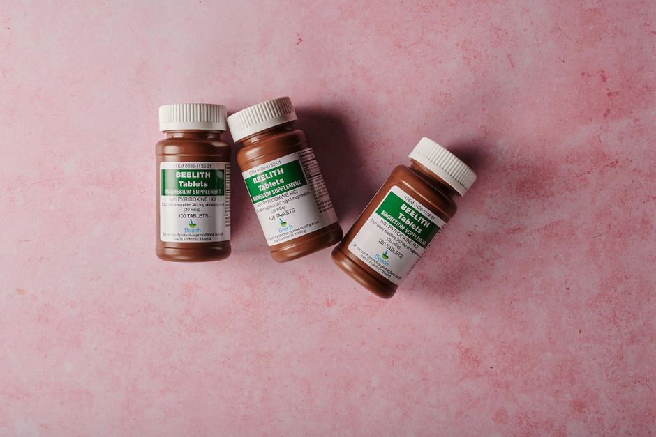 Een overzicht van populaire supplementen zoals magnesium, omega en creatine op een houten tafel met een gezonde achtergrond.