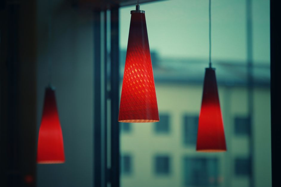 Moderne hanglampen boven een stijlvolle eettafel in een sfeervol interieur.